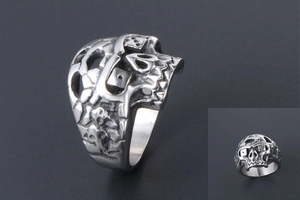 Macro detail of punk skull ring featuring a dice forehead and matte stainless steel finish