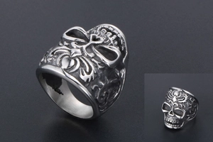 Detailed view of vintage gothic skull ring with heart crown and ornate vine carvings