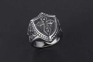 Detail of vintage gothic cross shield ring with intricate vine patterns in silver finish
