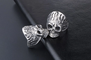 Close-up of silver skull rings with flame texture engraving in punk gothic style