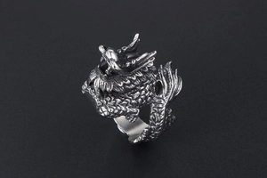 Detailed macro shot of vintage dragon ring featuring intricate scales and silver plating
