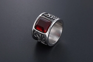 Macro view of wide silver ring band featuring red gemstone and Buddhist relief texture