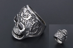 Macro detail of vintage skull ring featuring intricate scrollwork relief and silver finish