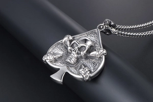 Macro shot of punk style spade pendant with embossed skull in polished silver finish