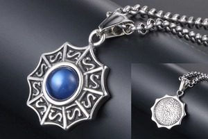 Détail du pendentif rond argenté avec pierre bleue et texture gravée motif en S