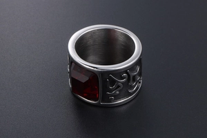 Macro shot of silver wide-band titanium ring with red gemstone and vintage carvings