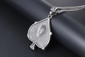 Close-up of vintage spade pendant with skull clasp and braided stainless steel chain