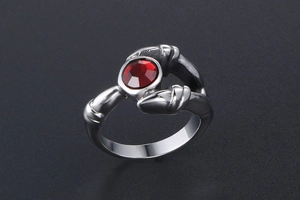 Macro shot of gothic titanium steel ring with red rhinestone and vintage claw design