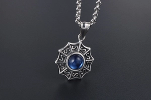 Vue macro du pendentif étoile argenté avec pierre bleue et motifs gravés