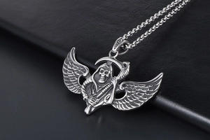 Close-up of gothic stainless steel flying reaper pendant with scythe and wings on chain