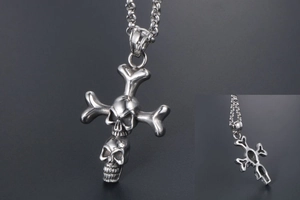 Macro shot of punk double skull cross pendant in stainless steel with metal link chain