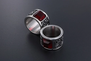 Macro shot of silver wide ring with square red gemstone and engraved patterns