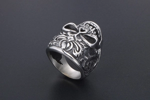 Detailed view of vintage gothic silver skull heart ring with intricate floral carvings