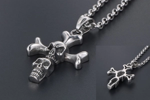 Detail view showing front and back of punk skull cross pendant in matte steel finish