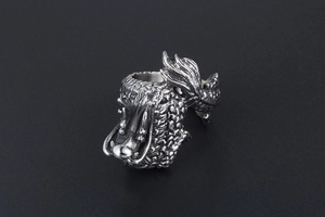 Macro detail of retro dragon ring featuring 3D embossed scales and antique silver finish
