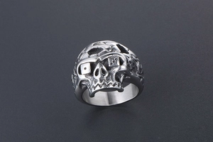 Close-up of vintage punk skull ring in stainless steel with dice eyes and aged finish