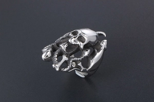 Détail d'une bague tête de mort gothique avec serpents en acier titane vintage
