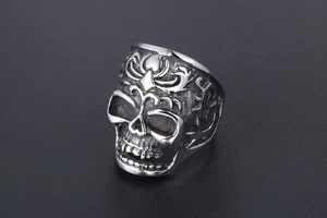 Close-up of vintage stainless steel skull ring with intricate baroque floral engravings