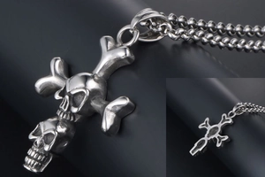 Close-up of vintage punk double skull cross pendant in distressed silver stainless steel