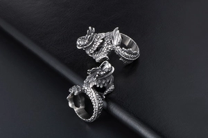 Detailed macro shot of vintage dragon rings featuring 3D carved scales and antique finish