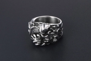 Macro view of vintage titanium steel ring featuring detailed koi fish and wave relief