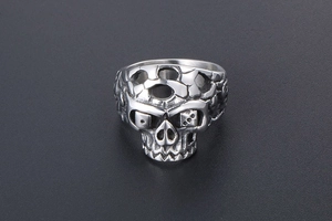 Macro detail of punk skull ring with dice eyes and textured finish in silver steel