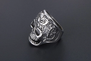 Detailed side view of vintage stainless steel skull ring with intricate vine carvings