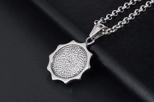 Détail macro du pendentif cercle argenté à bords ondulés avec texture et chaîne en O