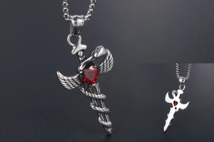 Detail of gothic silver sword pendant with red heart stone and serpent wrap design