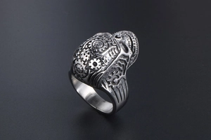 Detailed close-up of steampunk skull ring with gear embossing and vintage silver finish