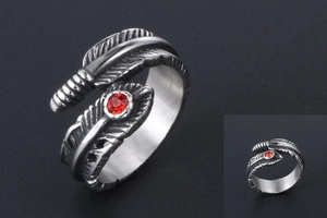 Macro detail of gothic feather ring with red rhinestone inlay in vintage silver steel