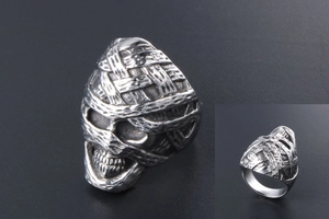 Macro detail of mummy skull ring in vintage silver punk style with bandage textures