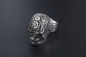 Detailed view of vintage punk skull ring with mechanical gear patterns in steel
