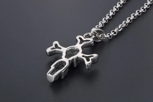 Macro side view showing the thick stainless steel cross pendant with skull details