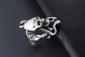 Gros plan d'une bague tête de mort gothique avec motif de serpent sur fond de cuir