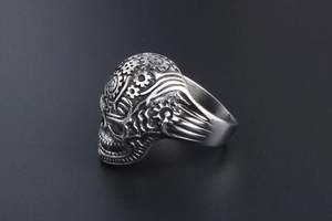 Macro side view of vintage stainless steel skull ring with gear textures and star engraving