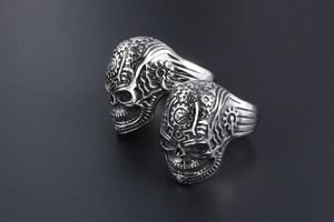Macro shot of vintage steampunk skull rings with mechanical gears and star engraving