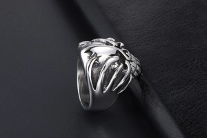 Macro view of vintage punk skull ring with detailed cast steel carvings on leather background