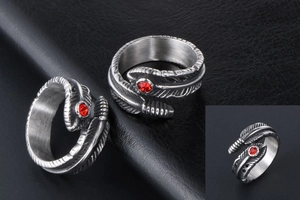 Detail of vintage gothic feather ring in titanium steel with a red zircon gemstone