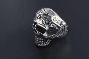 Macro detail of punk skull ring with vintage pilot goggles and oxidized steel finish