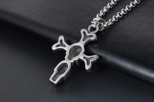 Detailed view of silver skull and cross pendant with punk style on black leather background