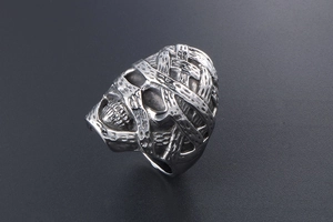 Macro detail of gothic mummy skull ring showing vintage punk steel texture and carving