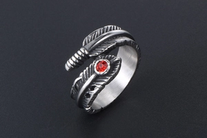 Detail of vintage feather ring in silver finish with a centered round red gemstone