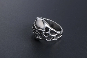 Close-up of gothic skull ring with hollow flame texture and polished silver metal finish