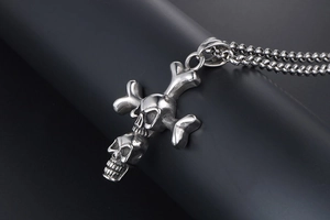 Close-up of vintage punk double skull crossbones pendant on stainless steel bead chain