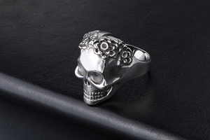Macro side view of skull ring featuring intricate floral carvings on stainless steel