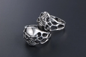 Detailed macro shot of gothic skeleton rings featuring intricate flame hollow carvings