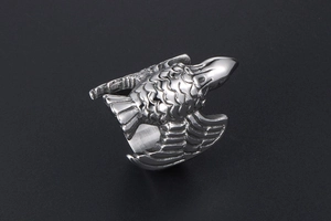 Macro detail of vintage eagle ring in silver-tone titanium steel with engraved feathers