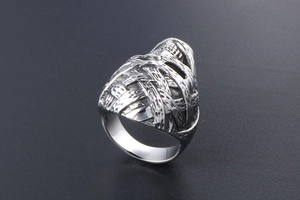 Macro detail of men's punk rock skull ring showing complex vintage silver textures