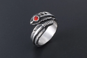 Close-up of vintage gothic feather ring in titanium steel with a red gemstone accent